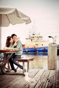 happy asian couple looking at seagulls Perth port jetty