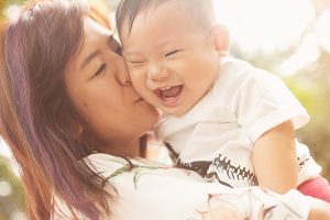 mother kissing laughing baby one year old baby shoot