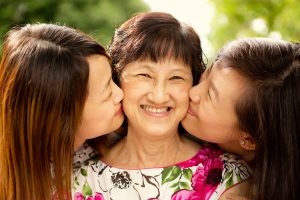 grown adult daughter kissing mother