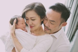 parents with newborn infant photoshoot home