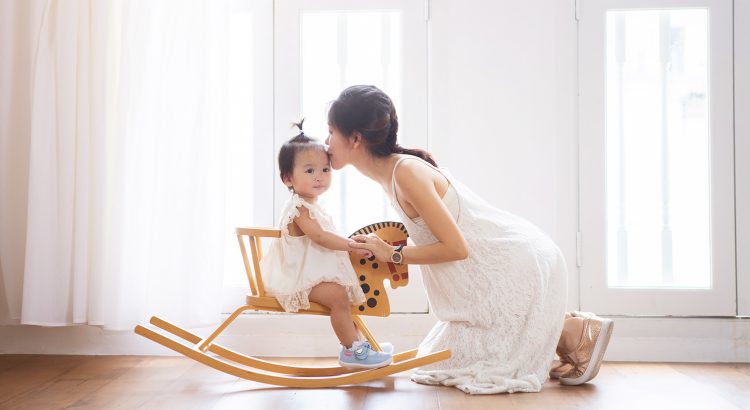 mother kissing daughter rocking horse oh dear studio