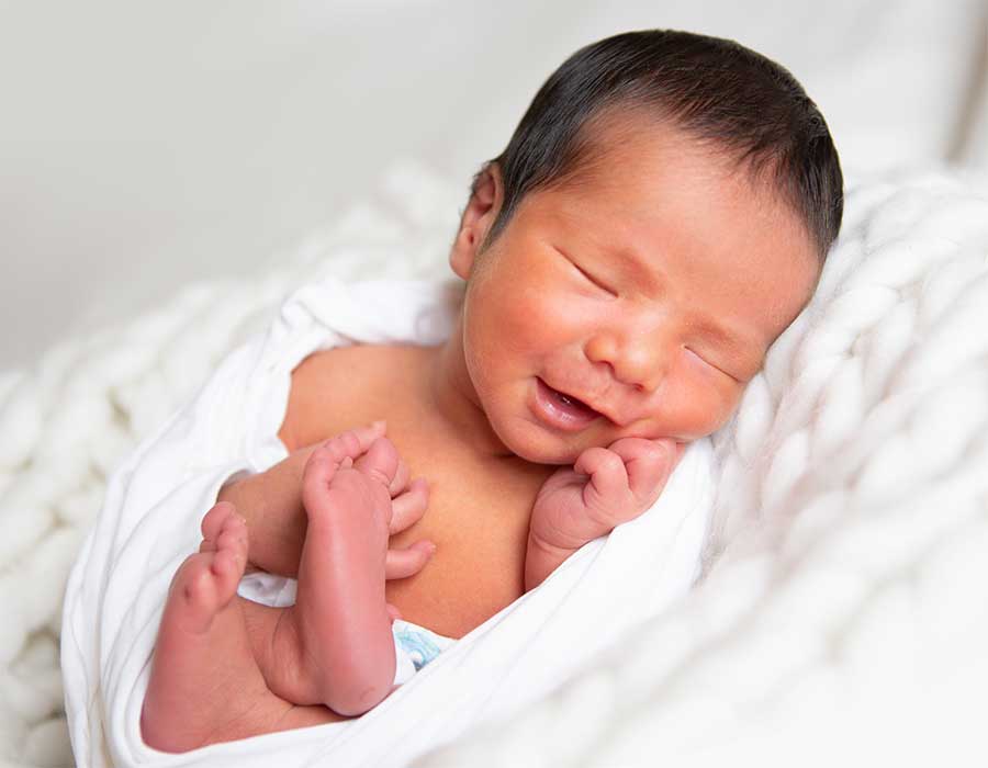 Smiling newborn infant photoshoot