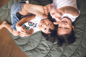 two brother playing on the floor smiling