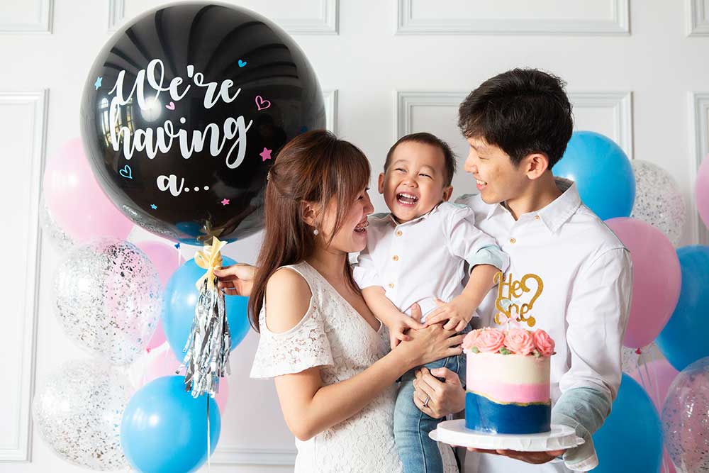 gender reveal photoshoot with cake and balloons