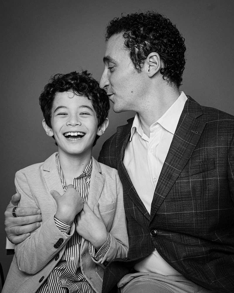 B&W photo of father kissing laughing son