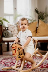 french toddler playing on rocking horse