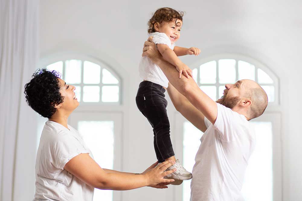 daddy carrying her daughter high up for a family photoshoot 