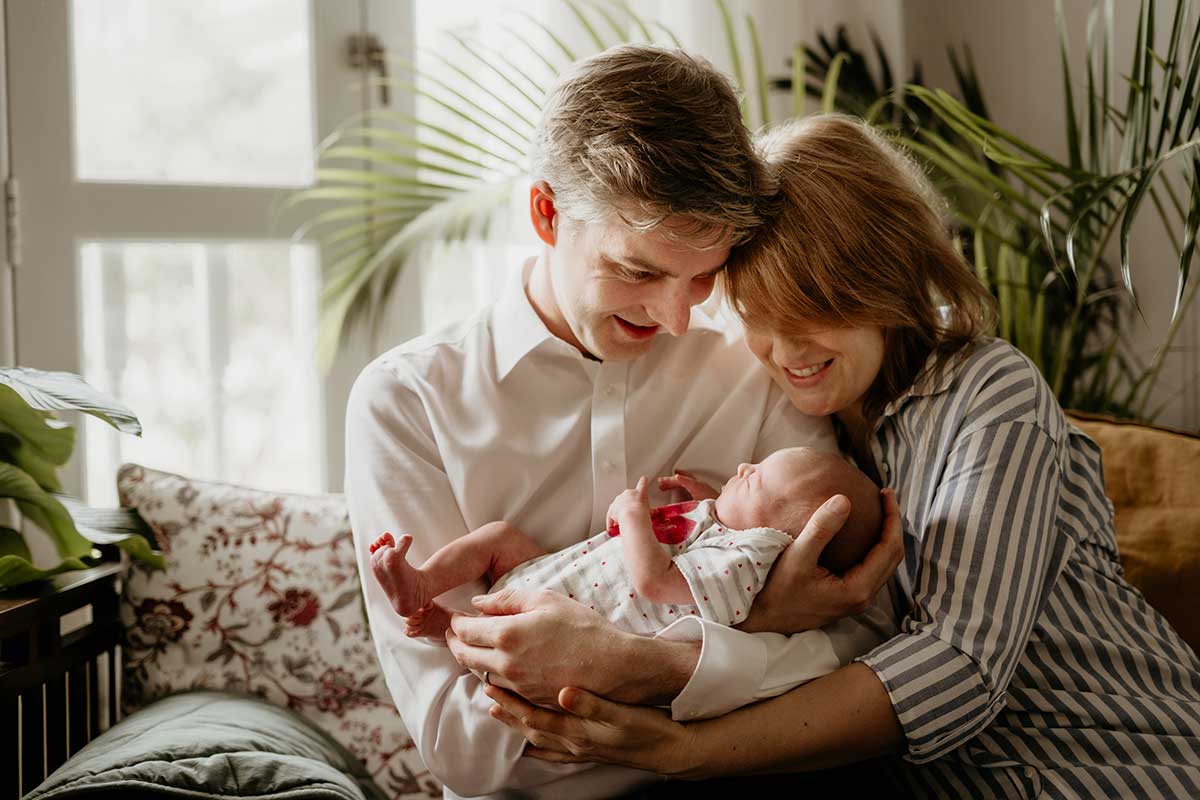 parents smiling at newborn baby photoshoot