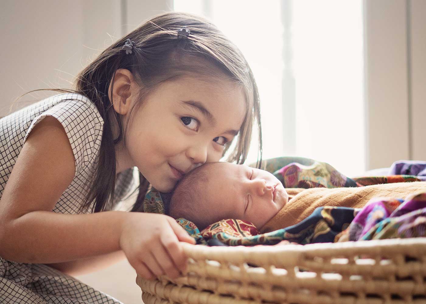 newborn with toddler sister kissing