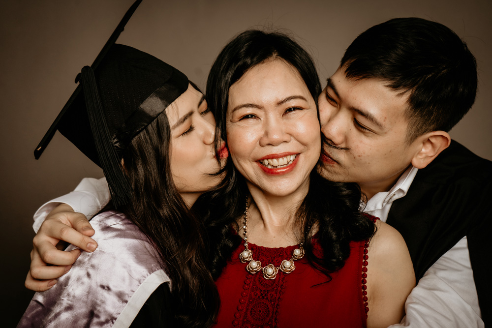 two graduate kissing laughing mother studio