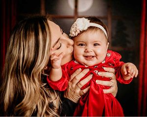 mother kissing laughing baby girl