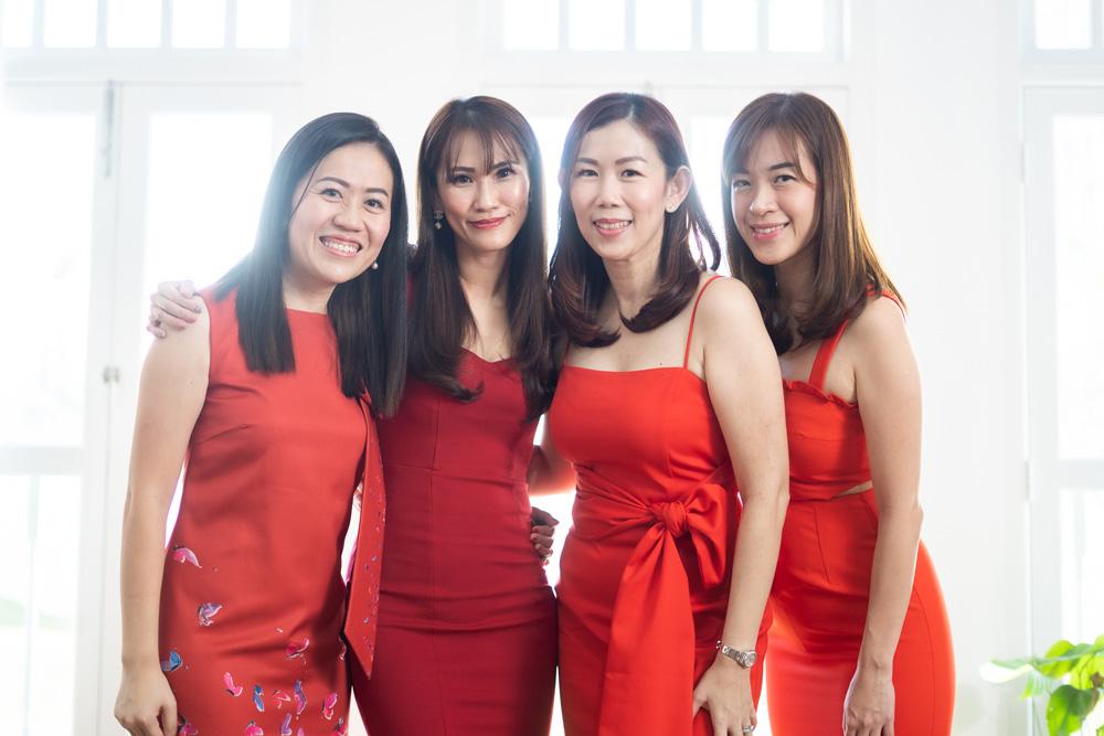 4 ladies in red dresses posing for a picture 