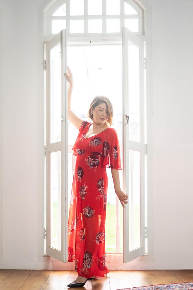 A portrait shot of a lady in a red flowy dress