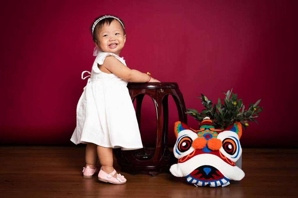 Baby girl in white dress posing in a CNY themed photoshoot