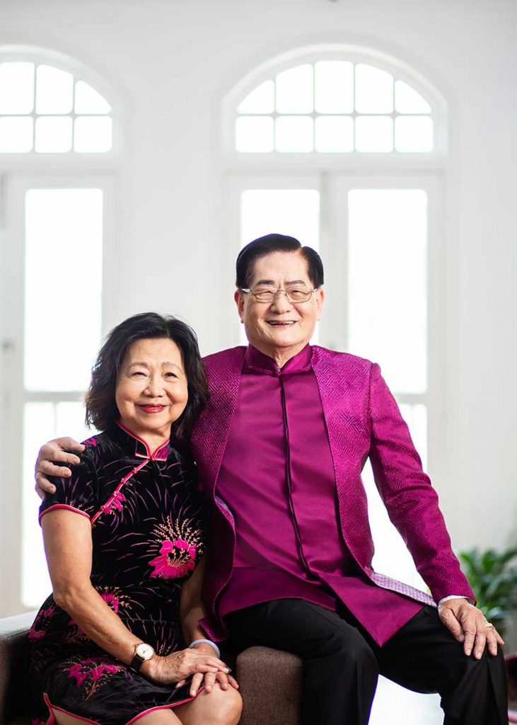 A couple smiling happily in an indoor photoshoot