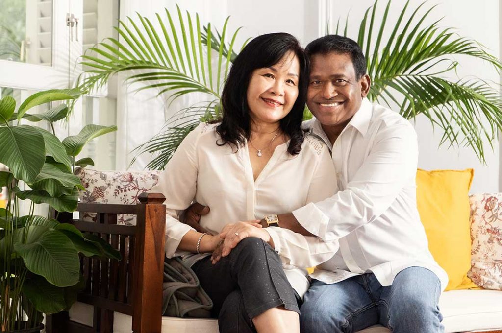 An interracial couple smiling happily in a photoshoot