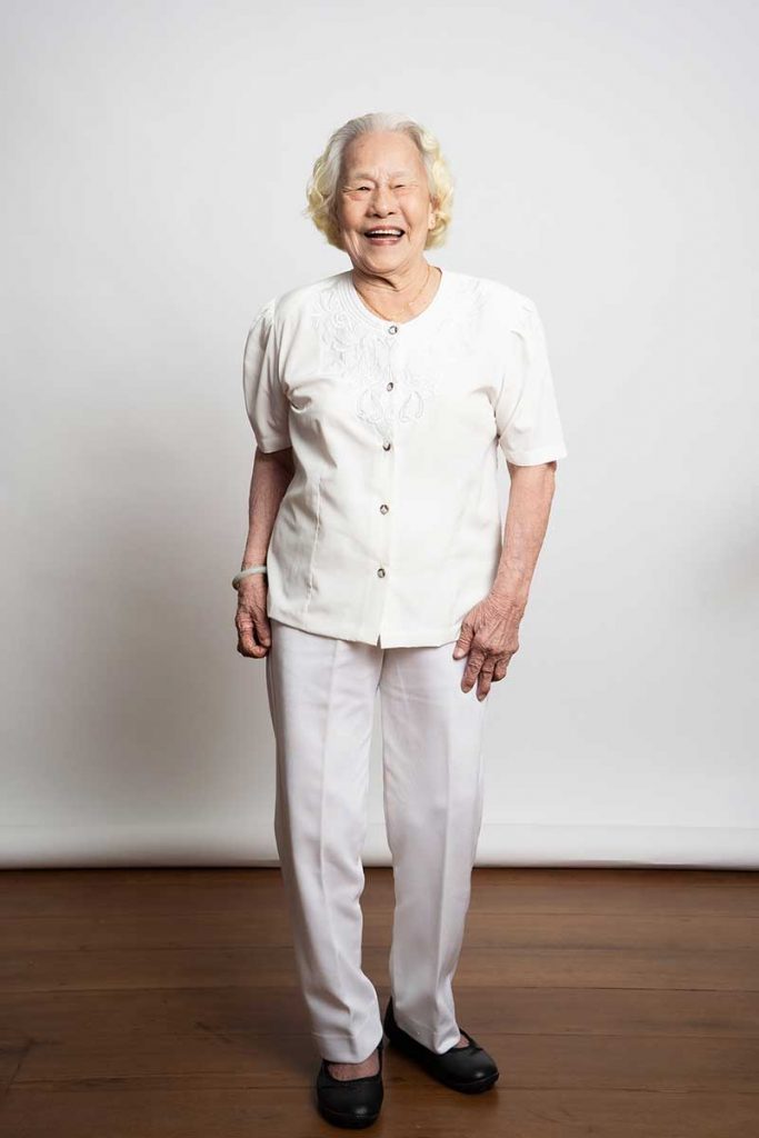 happy laughing elderly grandmother standing studio white