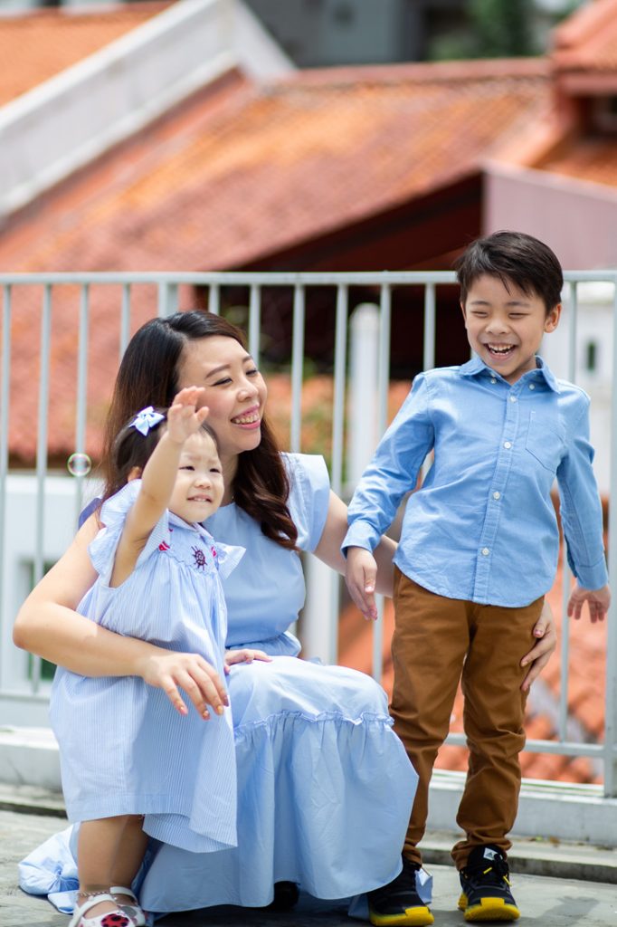 candid mother and two children on rooftop of OH DEAR STUDIO playing with bubbles