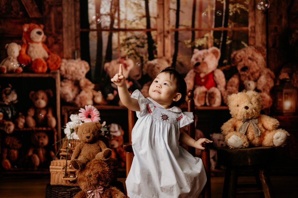 2 year old toddler girl photoshoot magic looking at bubbles