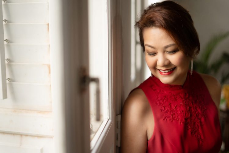 OhDearStudio_026 A lady in red looking down and smiling for the camera