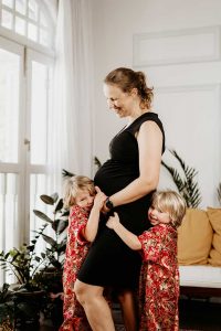 smiling expat maternity mother with two laughing children