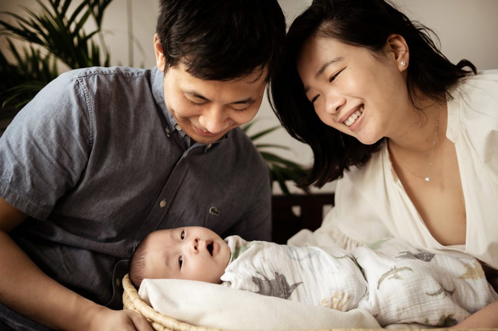 laughing happy parents with sleeping 100 day old baby in Oh Dear Studio