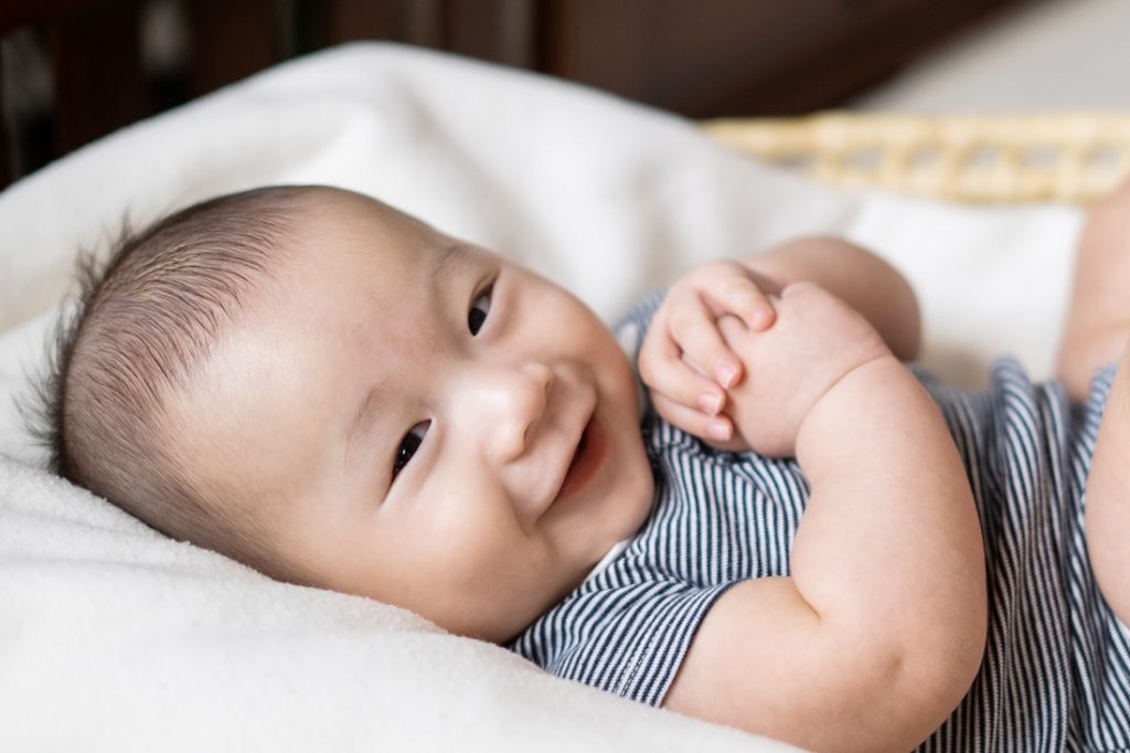 smiling happy 100 day old baby in basket