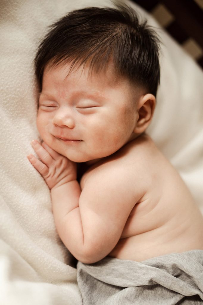 sleeping smiling newborn baby