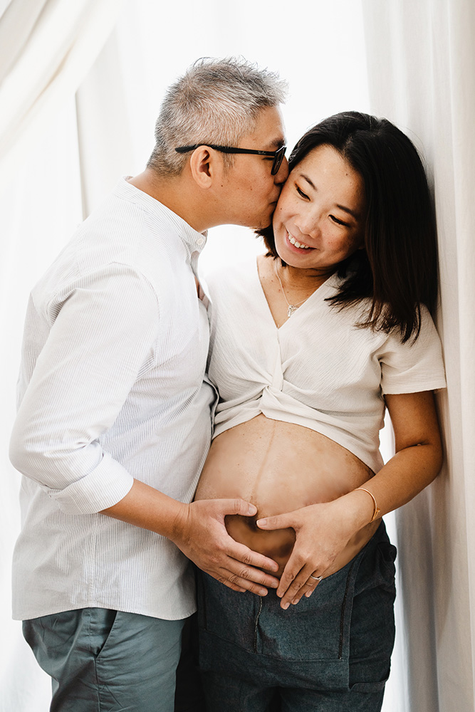 maternity photoshoot kissing smiling studio singapore
