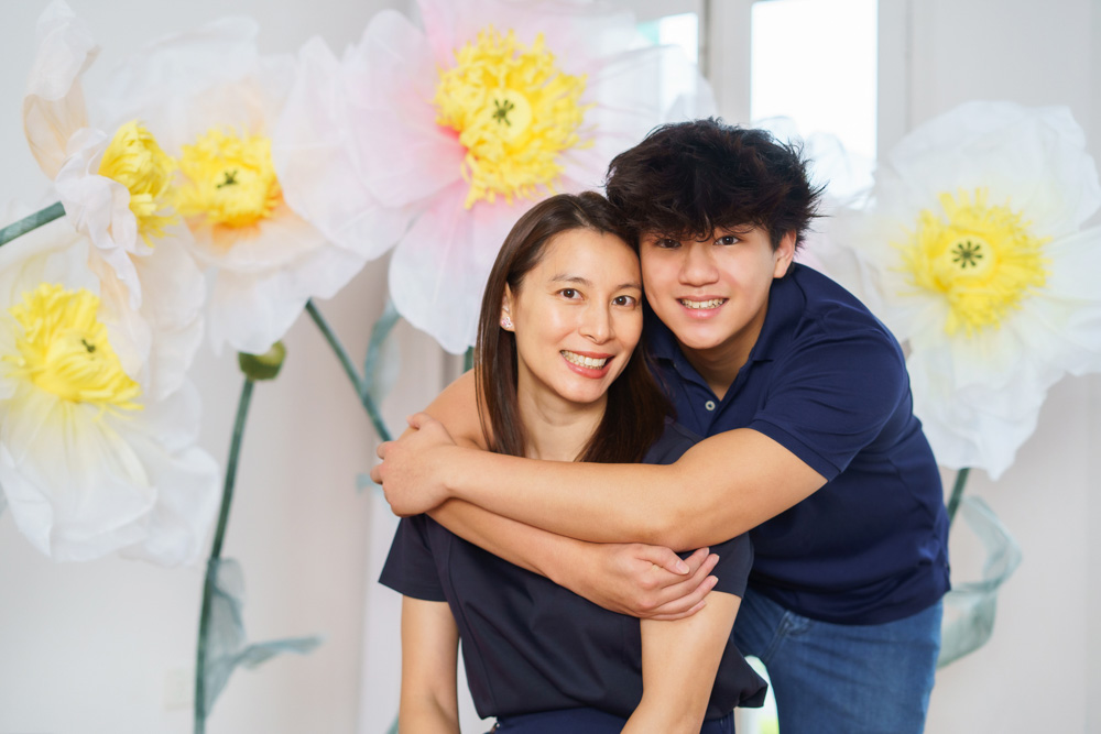 mother and teenager son flower photoshoot hugging smiling