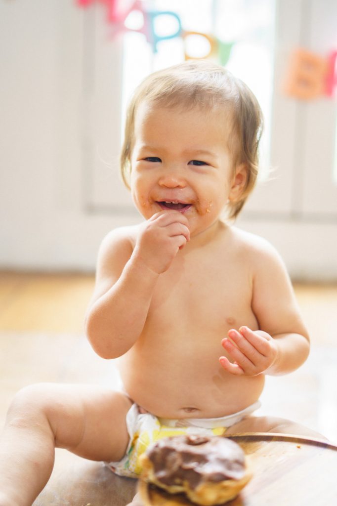 happy smiling baby smashing cake photoshoot