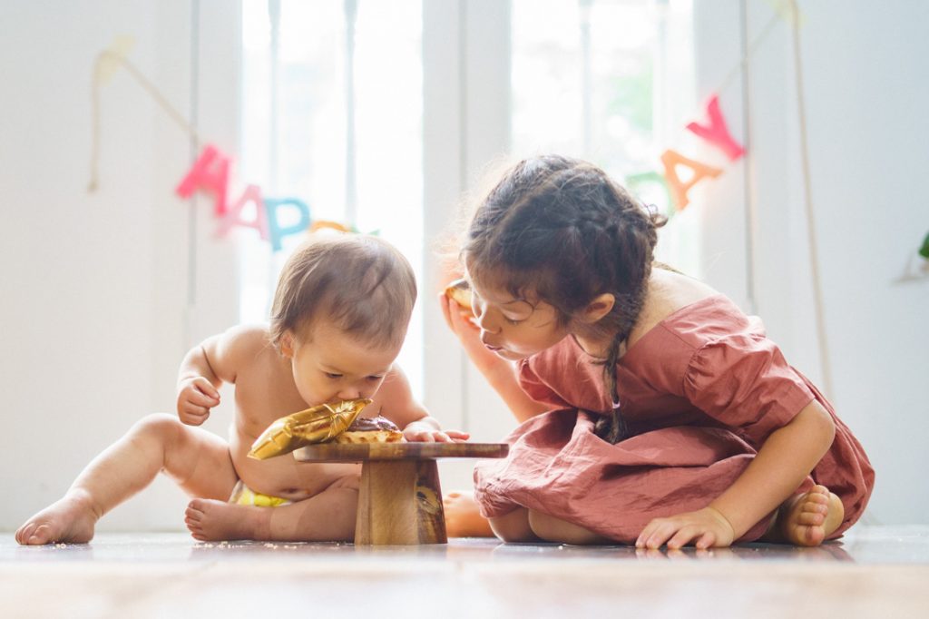 sibling smashing cake in studio