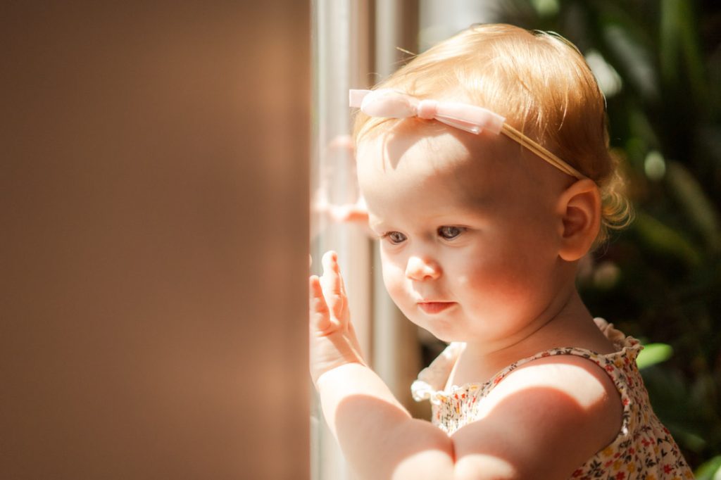 curious baby exploring Oh Dear Studio, looking out of window