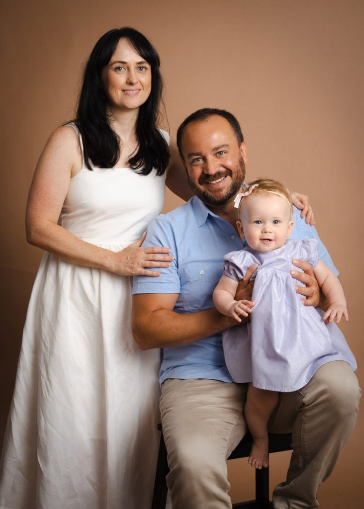 classic studio portrait one year old baby and parents