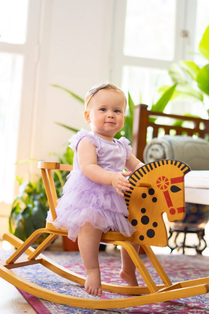 one year old baby on rocking horse