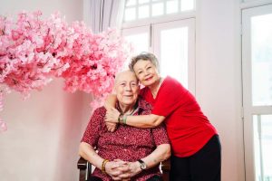 grandparents posing for couple shoot infront of pink sakura