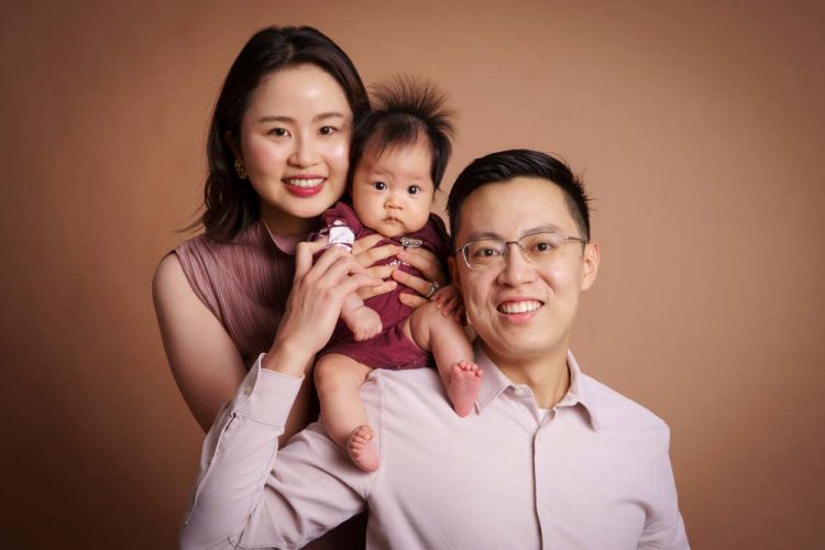 100-day-old-baby-photoshoot-with-parents parents with 100 day old baby in photo studio singapore