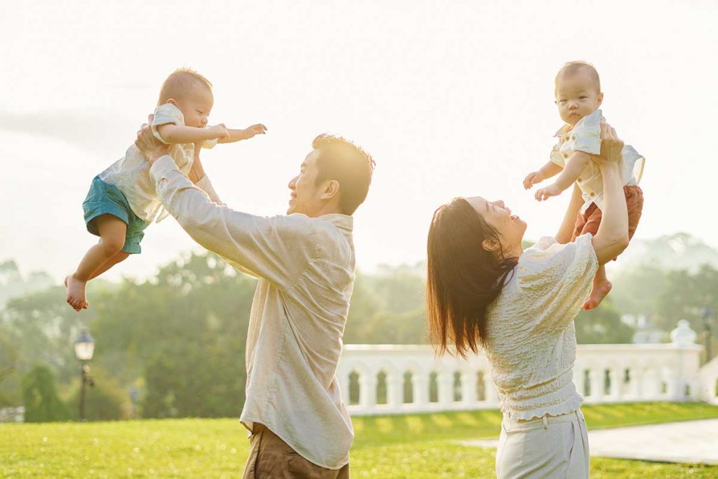 parents with twin baby one year old at botanic garden creamy bokeh