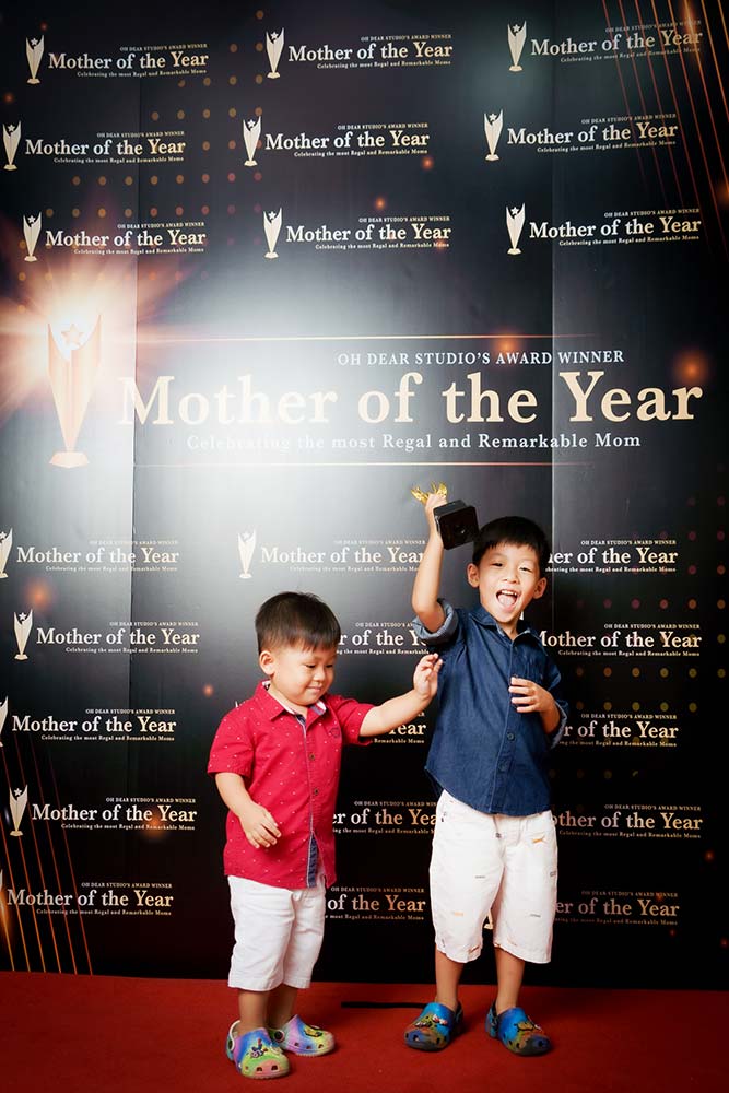 brothers happily holding trophy mothers day photography 2023