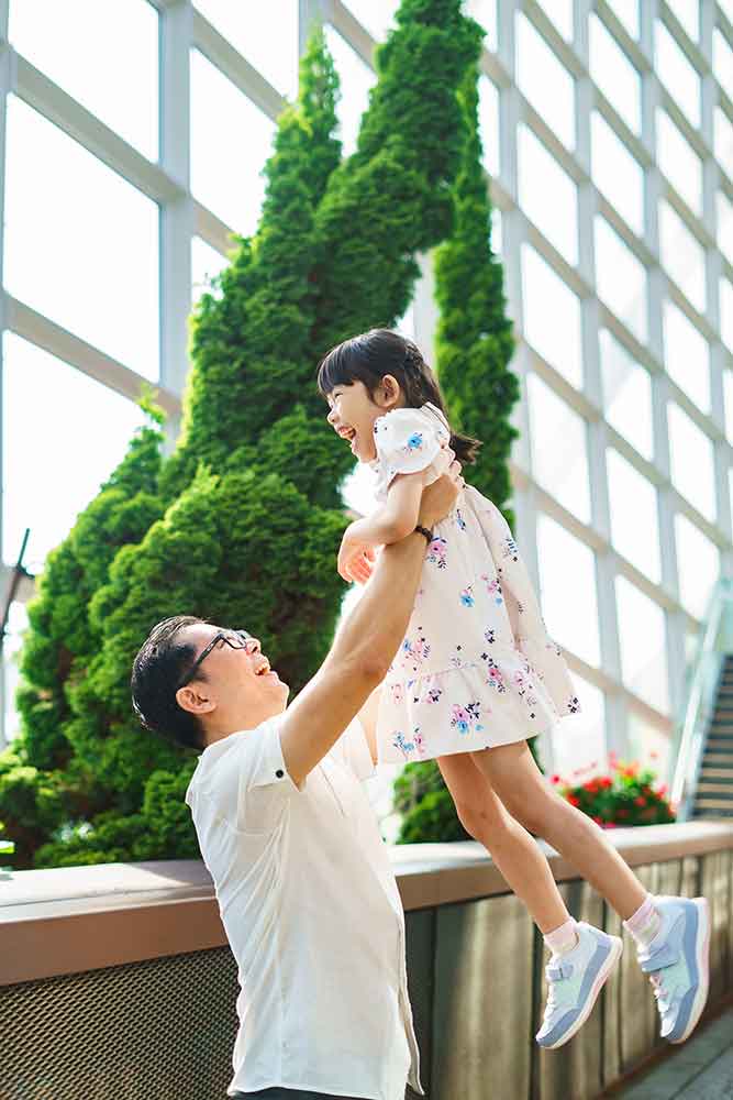 father and daughter playing candid laughing at gardens by the bay flower dome morning