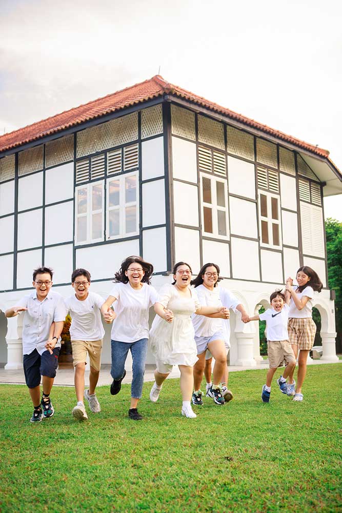 candid photo of cousins playing and running on open lawn