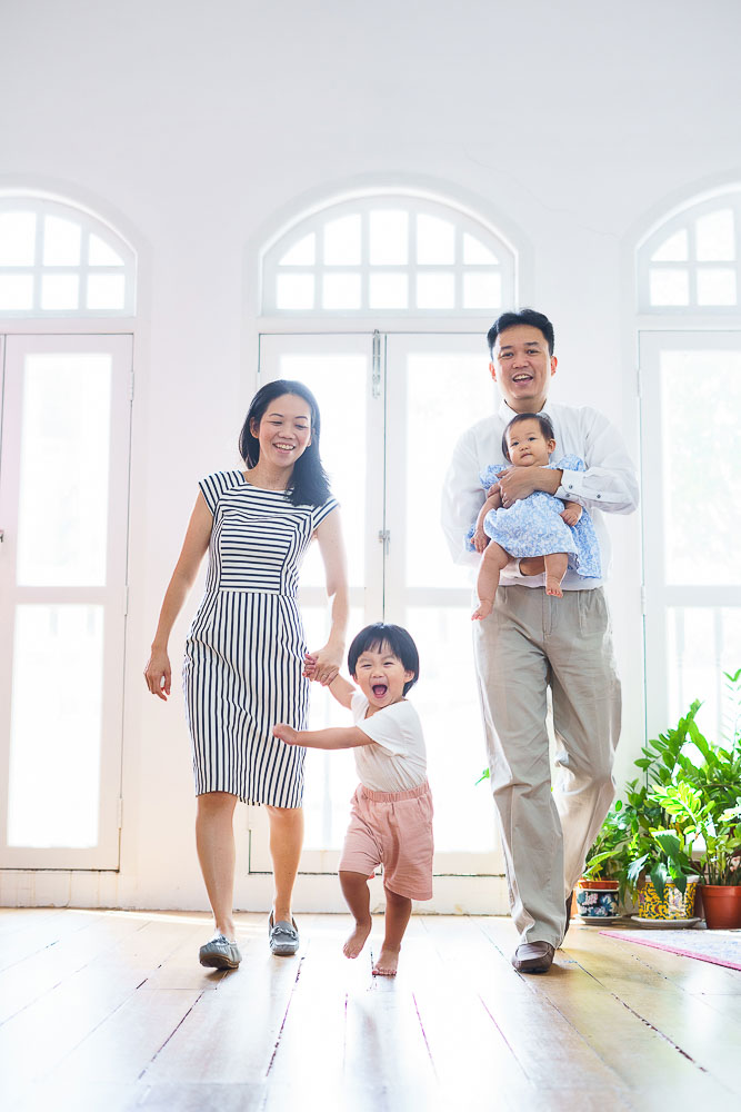 young family running towards camera smiling and laughing