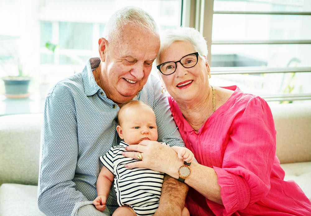 grandparents holding newborn baby smiling home photoshoot singapore