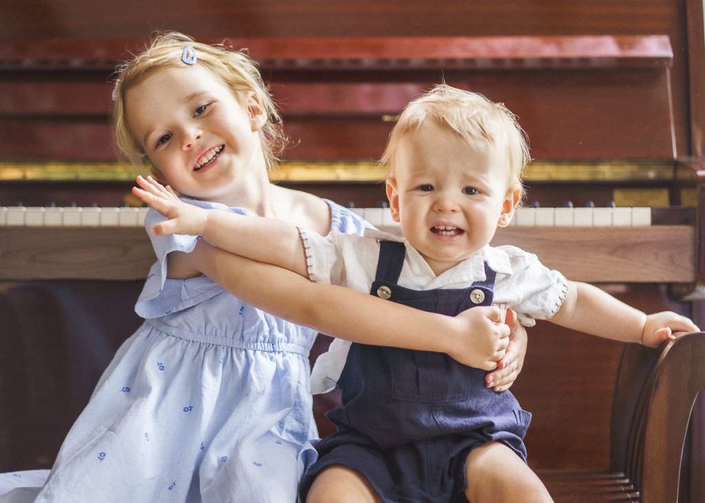 funny candid real moment baby brother pushing away loving hugging elder sister