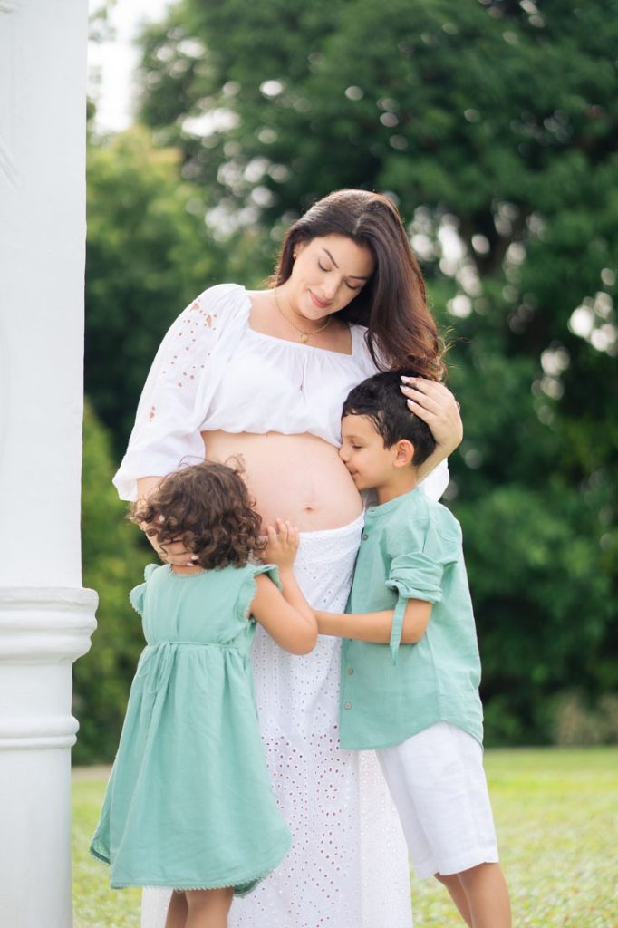 children kissing maternity pregnant mother's belly